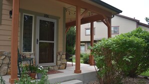 A house with a stone foundation, a porch with wooden columns, and a front door. - Quiet Loveland Escape – Close to Downtown, Parks & I-25 (Loveland)