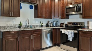 A modern kitchen with dark wood cabinets, stainless steel appliances, and granite countertops. - Lakeview Five Bedrooms Cape Cod Near Quantico and Historic Fredericksburg (Stafford Courthouse)