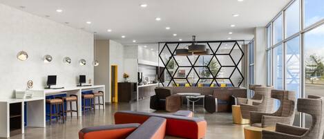 A modern lounge area with seating, a kitchen, and large windows.