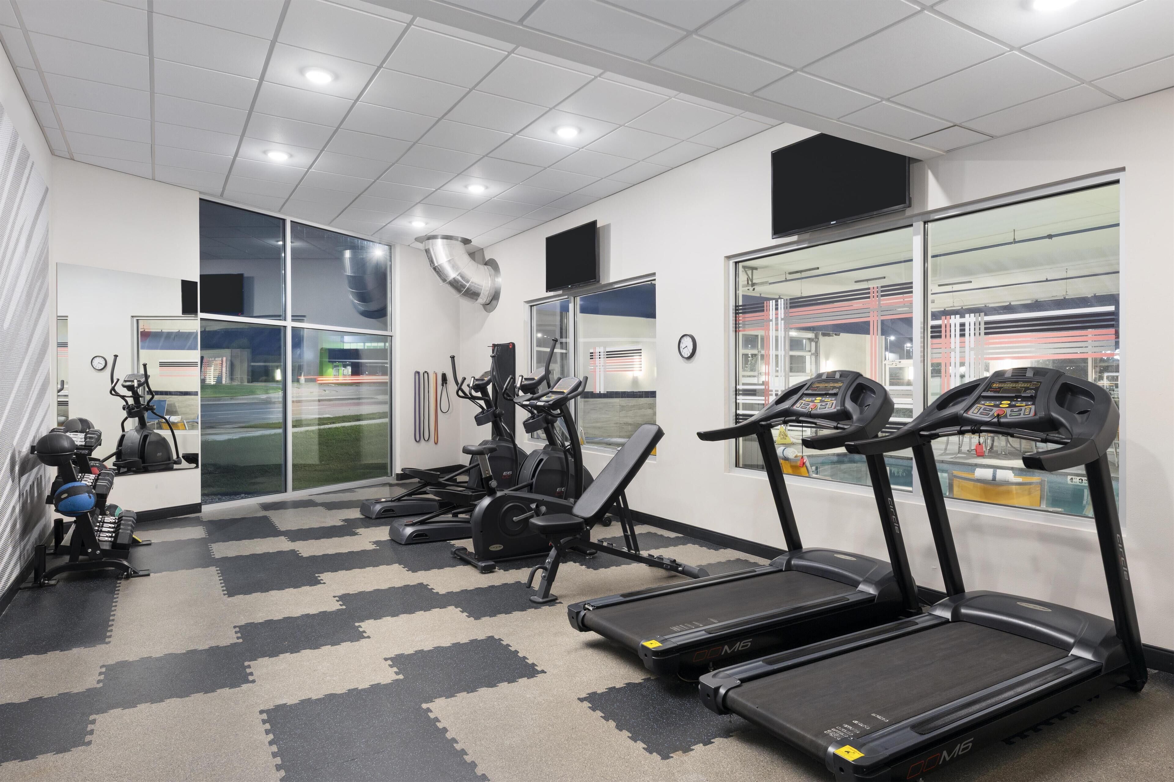 Et fitnesscenter med løbebånd, træningscykler og styrkemaskiner.