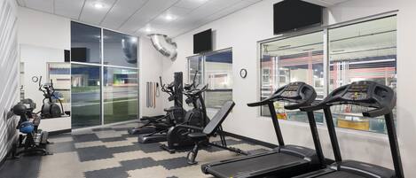 Et fitnesscenter med løbebånd, træningscykler og styrkemaskiner.