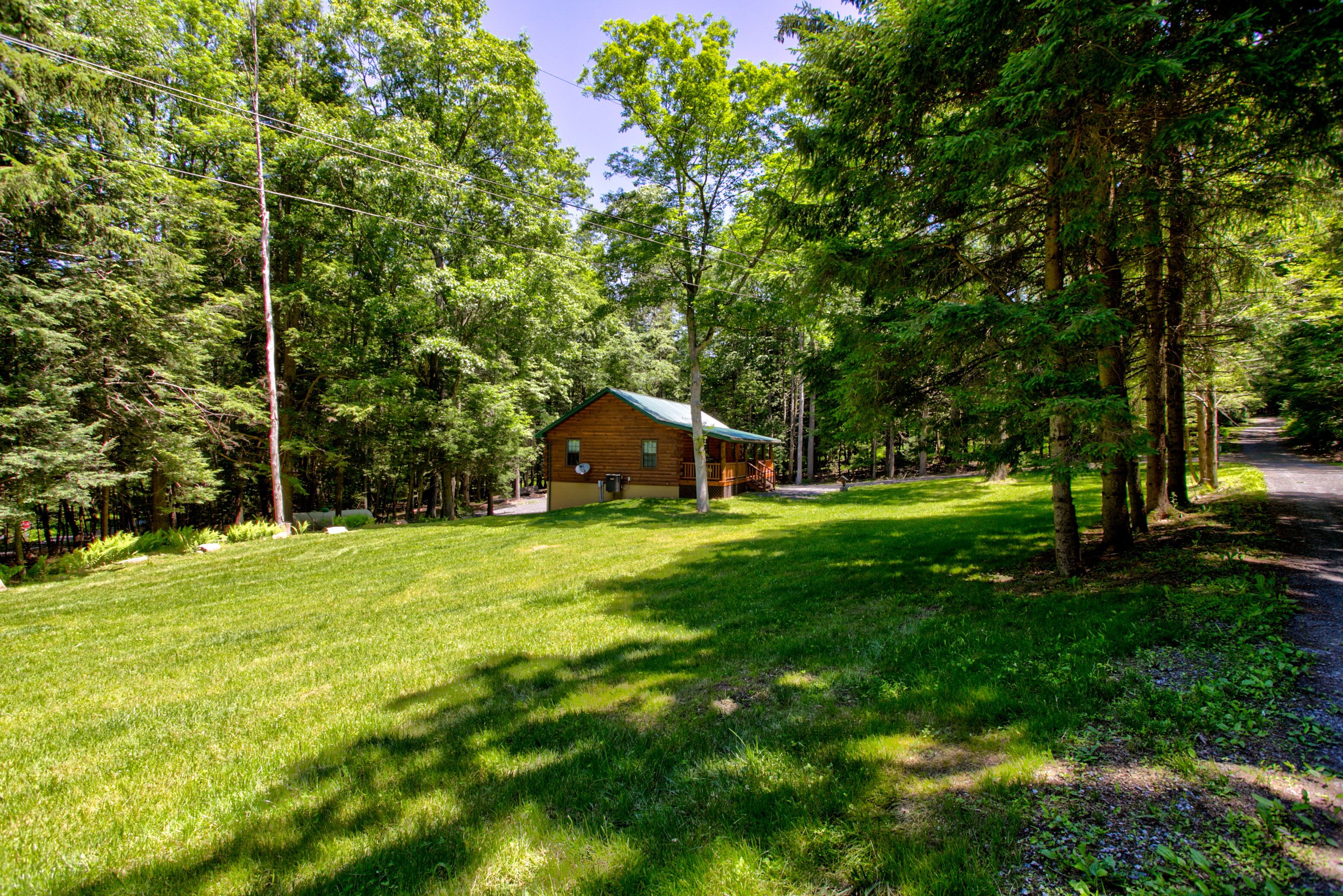 A cabin surrounded by a lush green landscape with a clear sky.