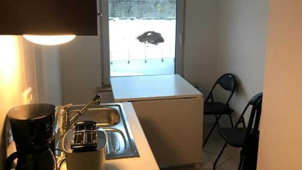 A compact kitchenette with a coffee maker, a toaster, a sink, and a window with a view of a parking lot. - Eversberg1 - Apartment/ Assembly Meschede-Eversberg (Meschede)