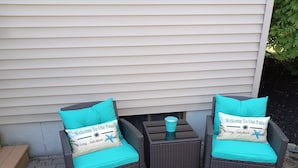 Two wicker patio chairs with turquoise cushions and a small table with a glass vase between them. - Cute and Comfy Cottage - 1 Mile to Wells Beach & 3 Miles to Ogunquit Beach! (Wells)