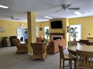 Relax in this inviting room with a high ceiling, wicker chairs, a sofa, and a flat-screen TV.