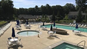 A pool area with multiple pools, lounge chairs, and umbrellas. - Cute and Comfy Cottage - 1 Mile to Wells Beach & 3 Miles to Ogunquit Beach! (Wells)