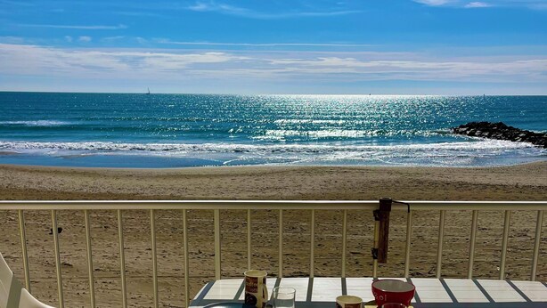A table with chairs and a view of the beach and ocean. - Nice air-conditioned studio - wifi - sea view and direct beach access (Palavas-les-Flots)