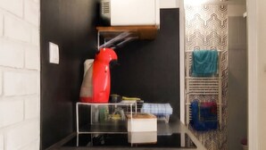 A compact kitchen with a countertop, a red kettle, and a microwave. - Homerez - Studio with parking in Montargis (Montargis)