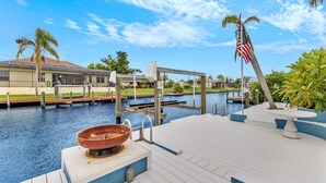 A waterfront deck with a copper basin, a flag, and a pool.