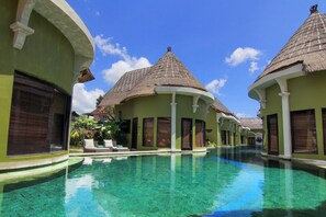 A resort with a clear pool, thatched-roof buildings, and a calm atmosphere. - 1BR Lagoon Villa in Seminyak, 35sqm Pool view, 5 mnts walk to shopping area (Kuta)