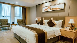 A hotel room with a large bed, two bedside tables with lamps, a chair, and a painting on the wall. - Days Inn by Wyndham Business Place Sichuan Bazhong (Bazhong)