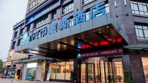 A hotel with a prominent sign, large windows, and a covered entrance area. - Days Inn by Wyndham Business Place Sichuan Bazhong (Bazhong)