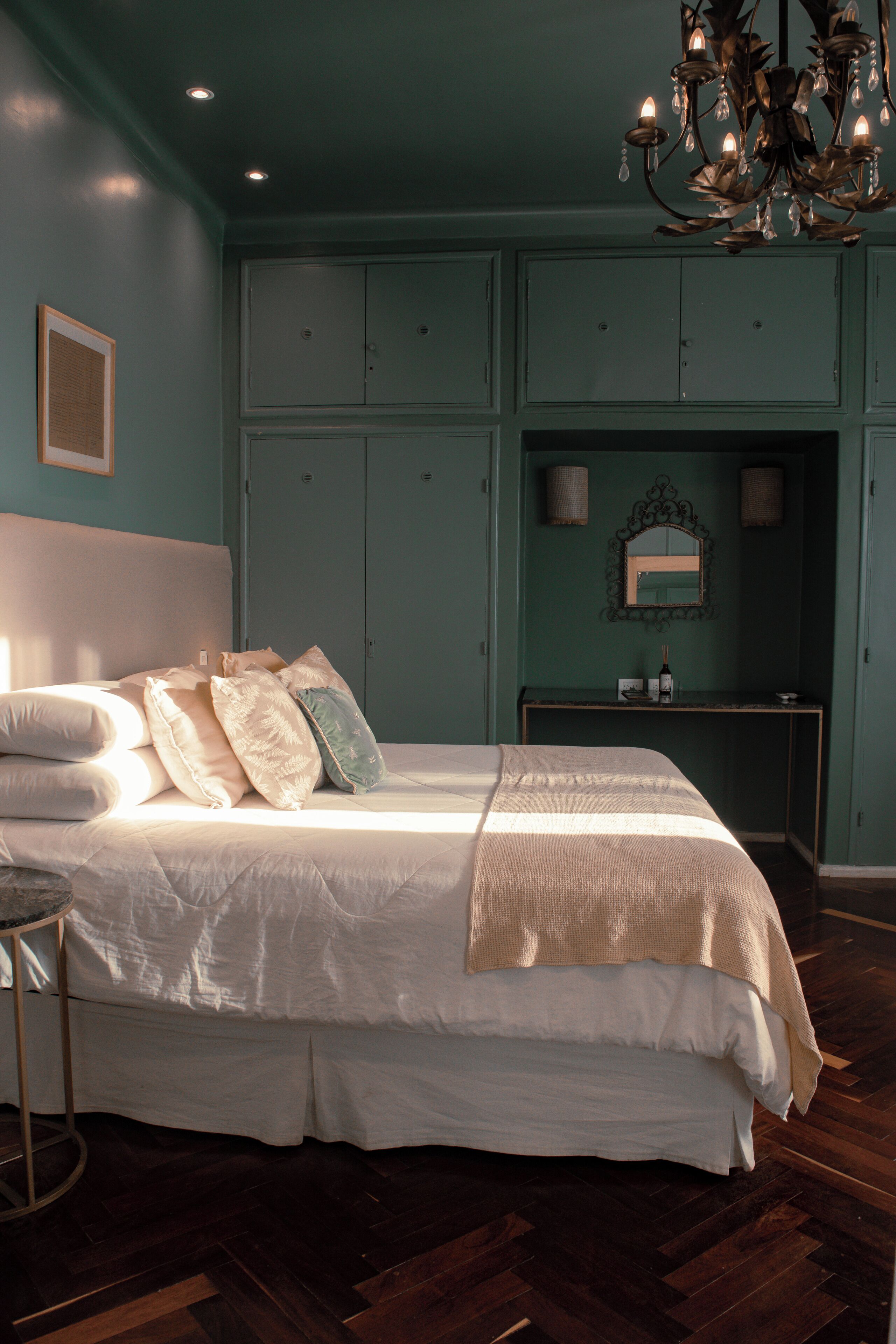 Een slaapkamer met een groot bed, een dressoir en een spiegel boven het dressoir.