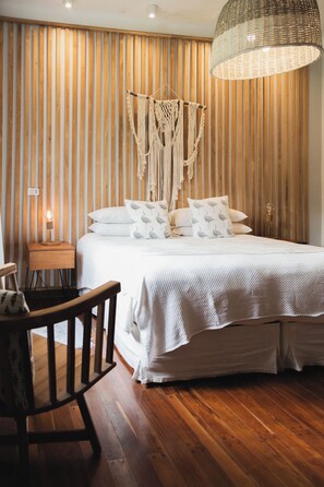 Cozy retreat with a bed, nightstand, and macrame light fixture.