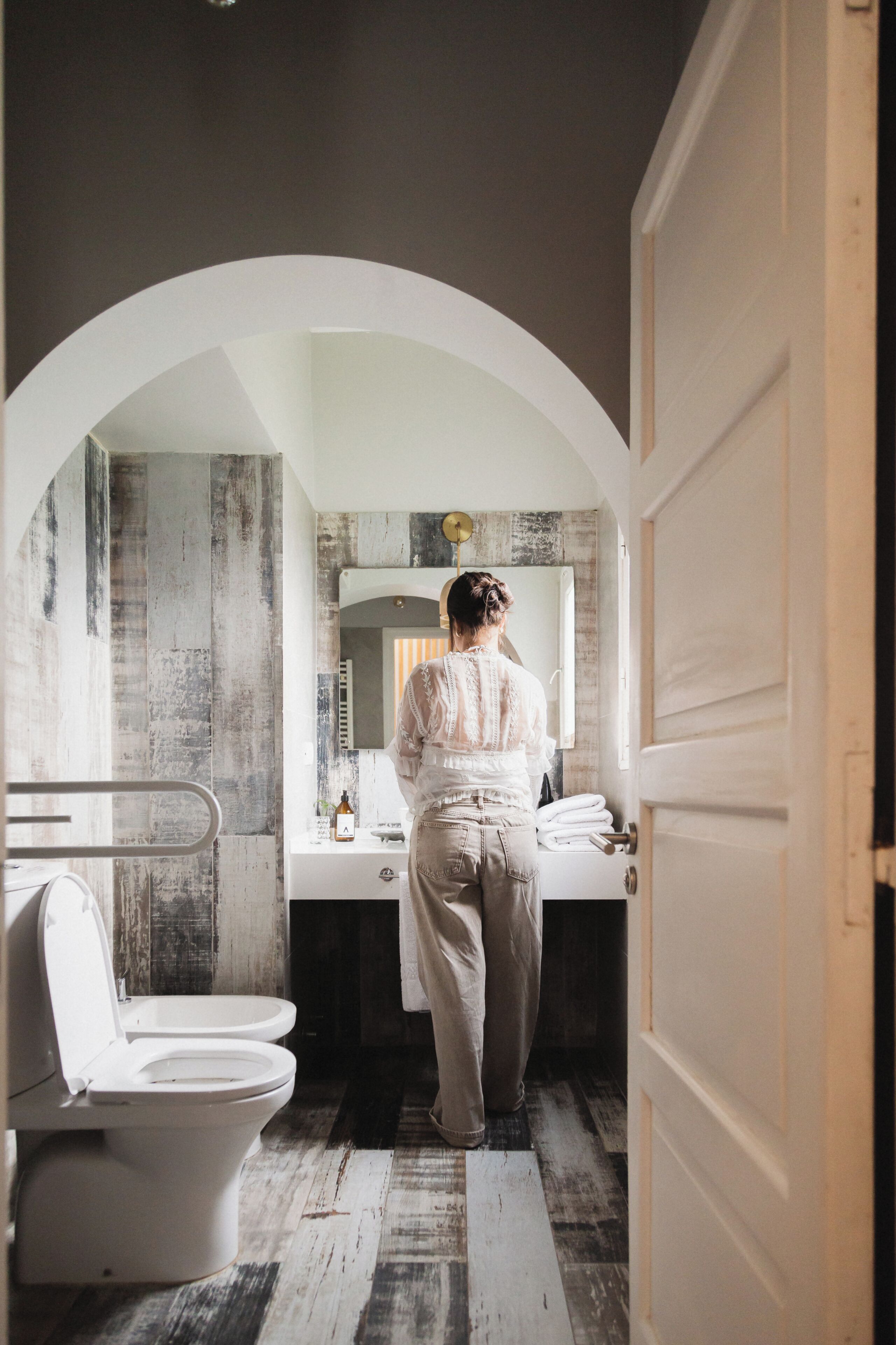 Un baño con inodoro blanco, lavabo y espejo.