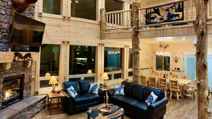 A spacious, multi-level lodge with a stone fireplace, leather sofas, and a dining area. - Imperial Elk Lodge-10 Miles to YNP+Sauna+Hot Tub+Wifi+AC (Island Park)