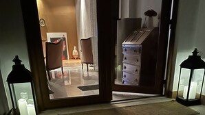 A room with a wooden dresser, a chair, and a rug on the floor.