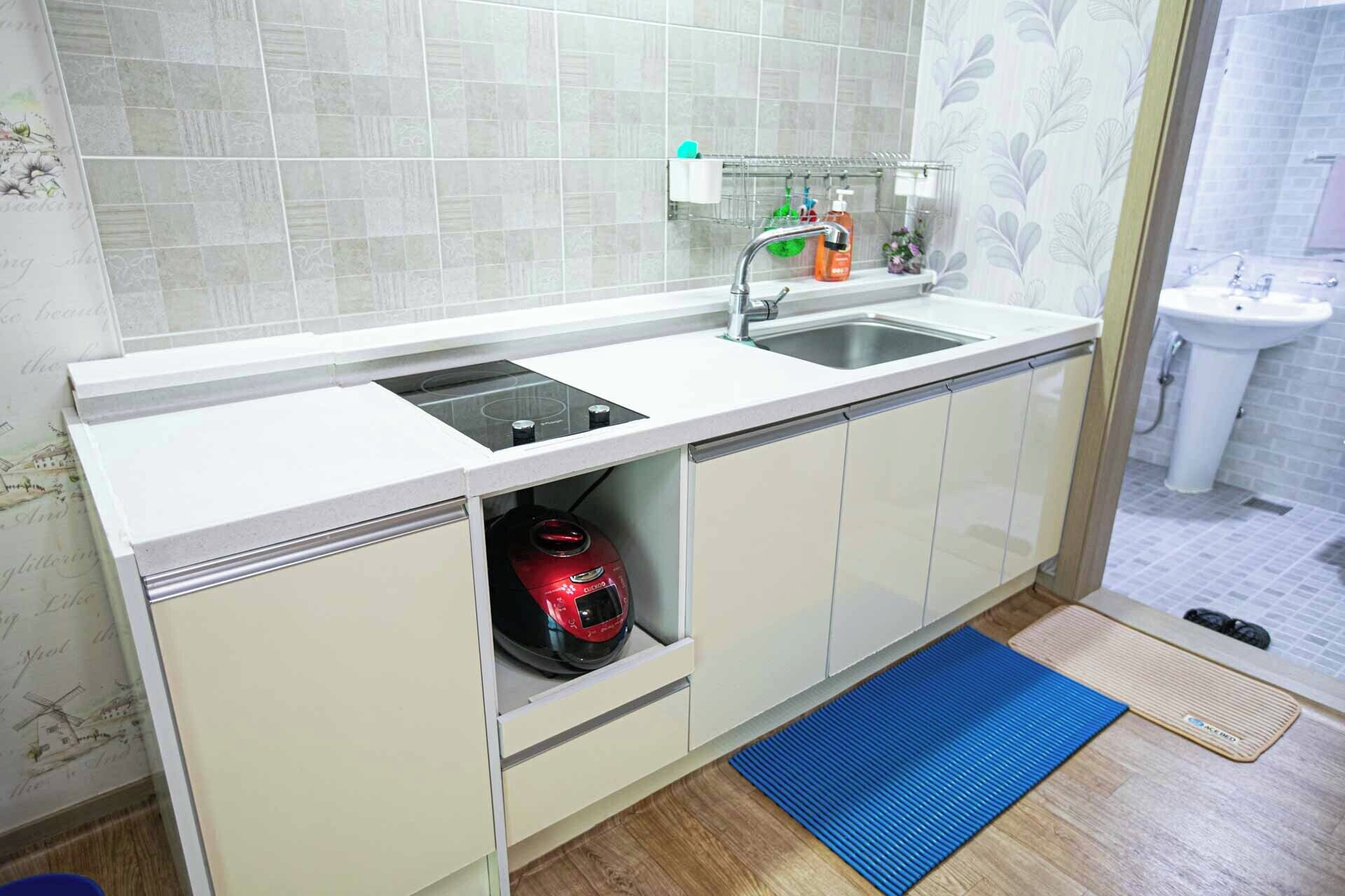 A kitchen with a double sink, a built-in stove, and a storage cabinet.