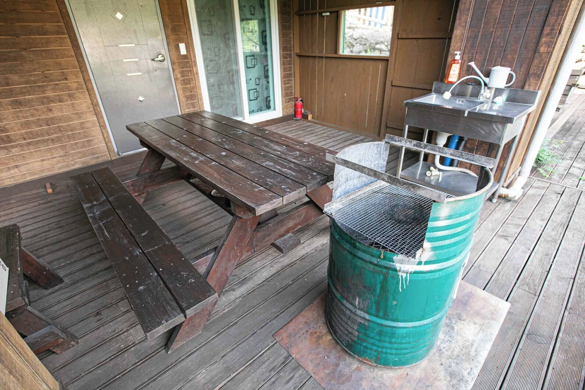 A wooden deck with a picnic table and a grill.