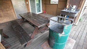 A wooden deck with a picnic table and a grill.