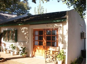 Traditional building with a welcoming porch and potted plants.