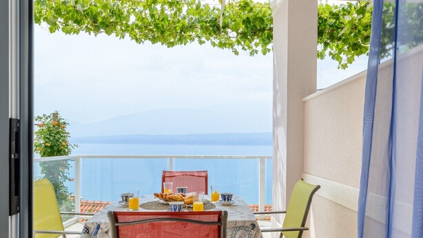 A balcony with a table set for breakfast, chairs, and a view of the sea. - Apartments Hope (Dugi Rat) - One-Bedroom Apartment with Terrace and Sea View (A2) (Dugi Rat)