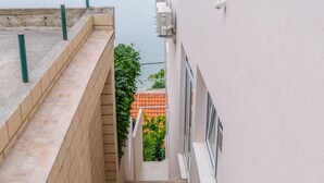 A staircase leading to a balcony overlooking a body of water. - Apartments Hope (Dugi Rat) - Standard One-Bedroom Apartment with Terrace and Sea View (A3) (Dugi Rat)