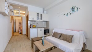 A compact living space with a kitchenette, a dining area, and a sofa. - Apartments Hope (Dugi Rat) - Standard One-Bedroom Apartment with Terrace and Sea View (A3) (Dugi Rat)