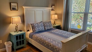 A bedroom with a bed, two nightstands, two lamps, a window with blinds, and a picture on the wall. - Rye Beach Lake Front Home near Cedar Point (Huron)