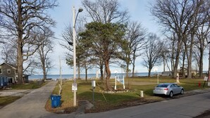 A residential street with a parked car, a blue trash bin, and a sign indicating a private property with no trespassing. - Rye Beach Lake Front Home near Cedar Point (Huron)