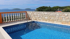 A swimming pool with a stone wall and a view of the sea. - Holiday Home Adriatic View-Five Bedroom Holiday Home with Pool and Sea View (Blato)