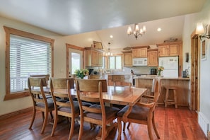 A kitchen with wooden cabinets, a dining table with chairs, and a central island. - Nestled in the mountains, 20 min ➡️ Yellowstone,  AC, WI-FI, Large Porch 🏕️ (Island Park)
