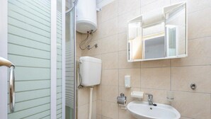 Un baño con inodoro, lavamanos y ducha.