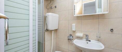 Un baño con inodoro, lavamanos y ducha.