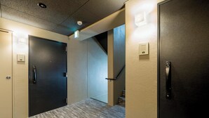 A hallway with two doors, a staircase, and a textured floor. - RESI STAY ANDON  (Kyoto)