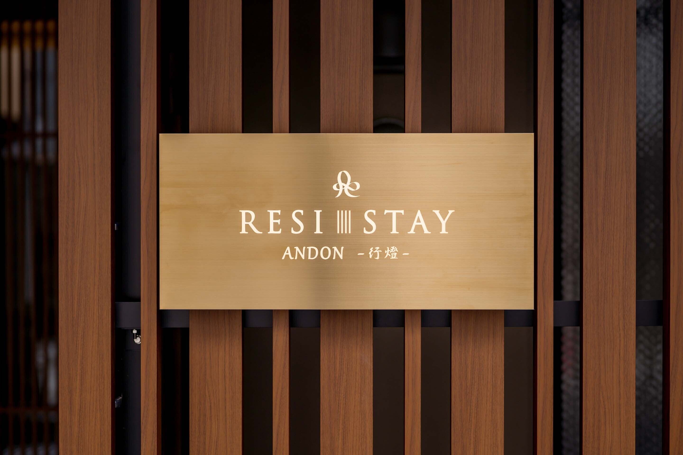 A wooden sign with the text "RESI STAY ANDON - 行燒-".