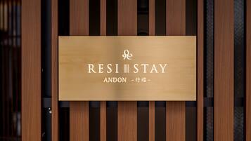 A wooden sign with the text "RESI STAY ANDON - 行燒-".