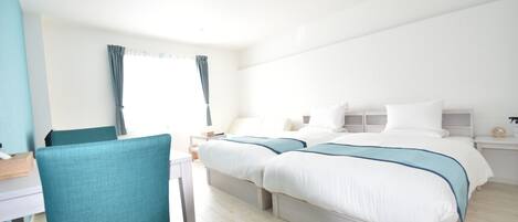 A hotel room with a bed, bedside tables, a desk, and a chair.