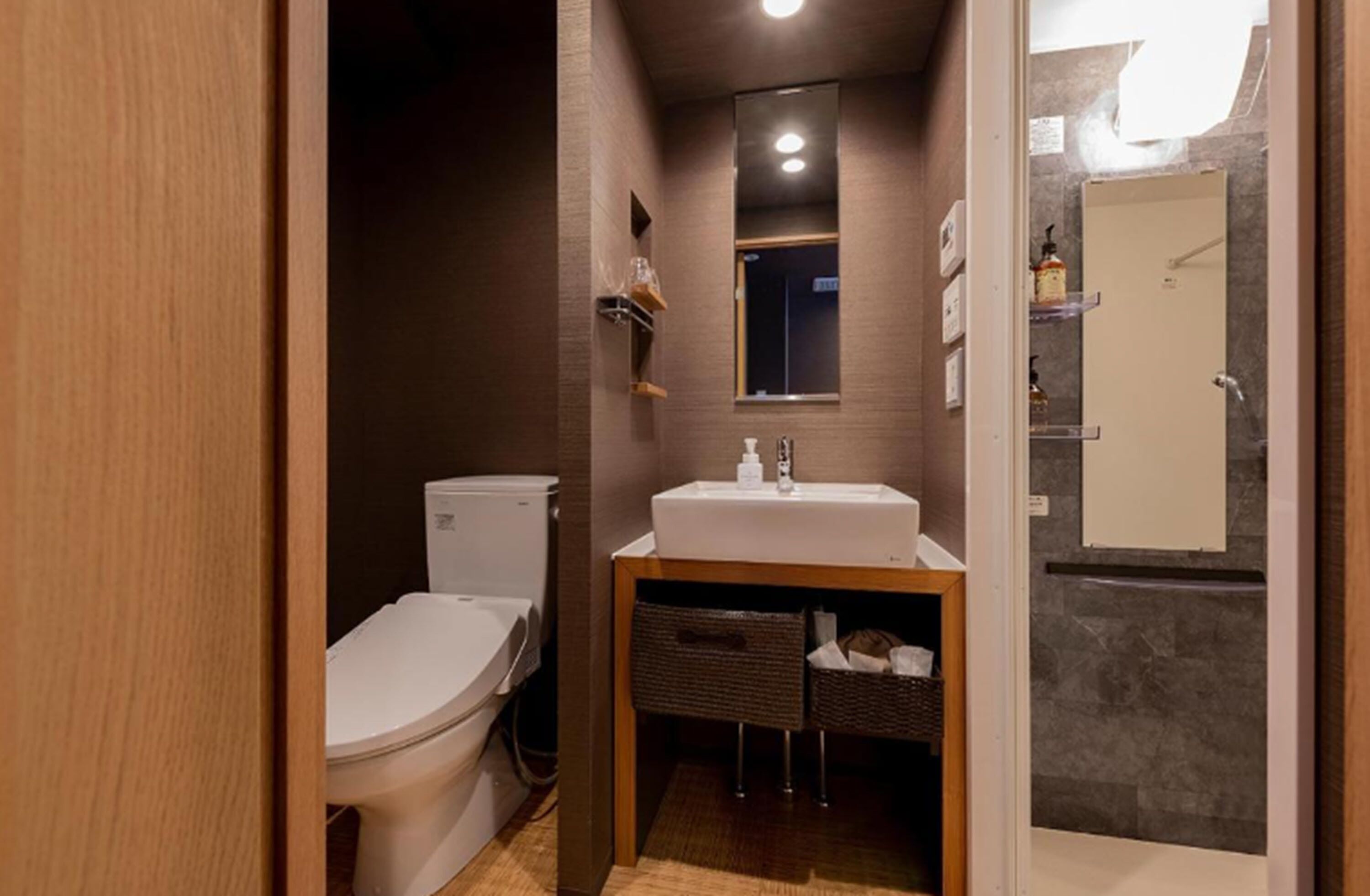 A compact bathroom with a toilet, sink, and shower area.