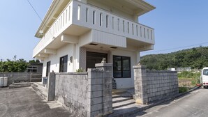 A two-story house with a balcony, a garage, and a driveway. - Maru House (Uruma)