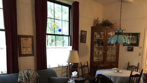 Ein gemütliches Wohnzimmer mit einer Couch, einem Holztisch, einem Esstisch mit Stühlen und einer Chandelier.