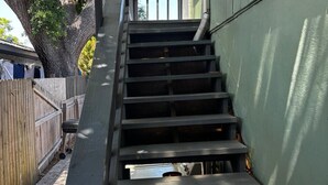 Una serie de escaleras exteriores que conducen a un edificio con una pared verde.