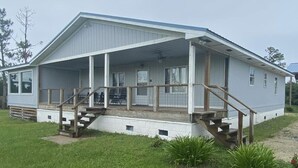 A single-story house with a covered porch and a small set of wooden stairs leading to the entrance.