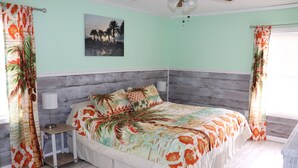 A bedroom with a bed, nightstand, and a ceiling fan.