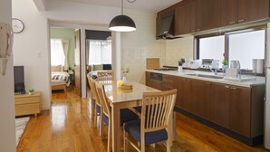 Una cocina moderna con armarios de madera, una mesa de comedor con sillas y un horno empotrado.