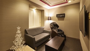 A modern room with a sofa, massage chair, and a small table. - Hotel Christmas (Inazawa)