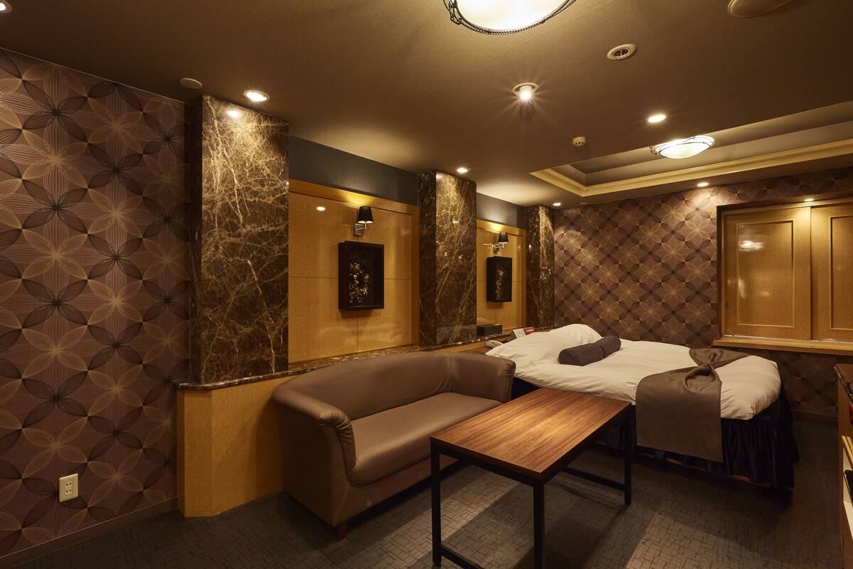 Une chambre d’hôtel avec un canapé, une petite table et un lit.