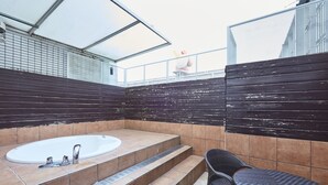 A bathroom with a bathtub, a chair, and a small table. - Hotel Christmas (Inazawa)