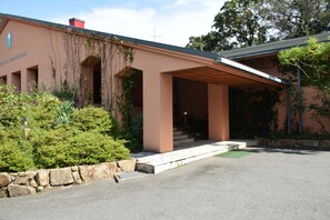 A building with a covered entrance, stone steps, and greenery around. - Taiyou no Ouchi (Tonosho)