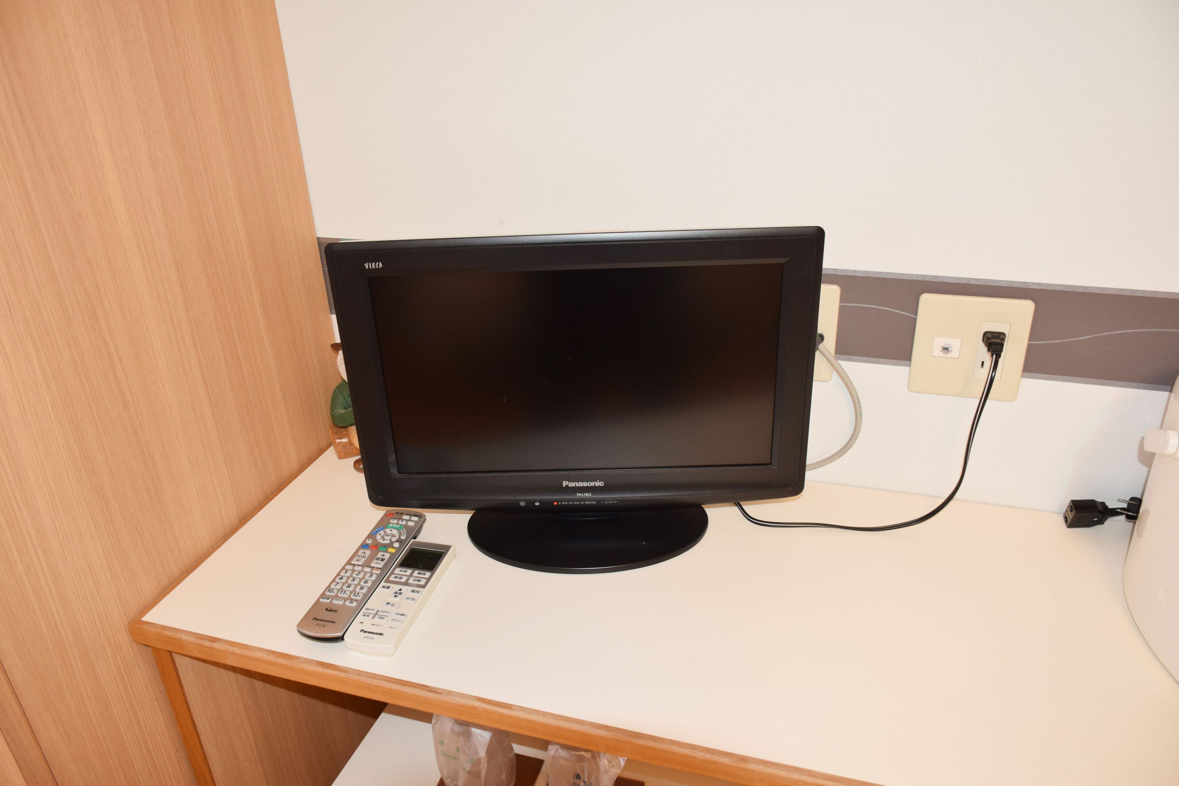 Un televisor sobre una mesa blanca con un control remoto.